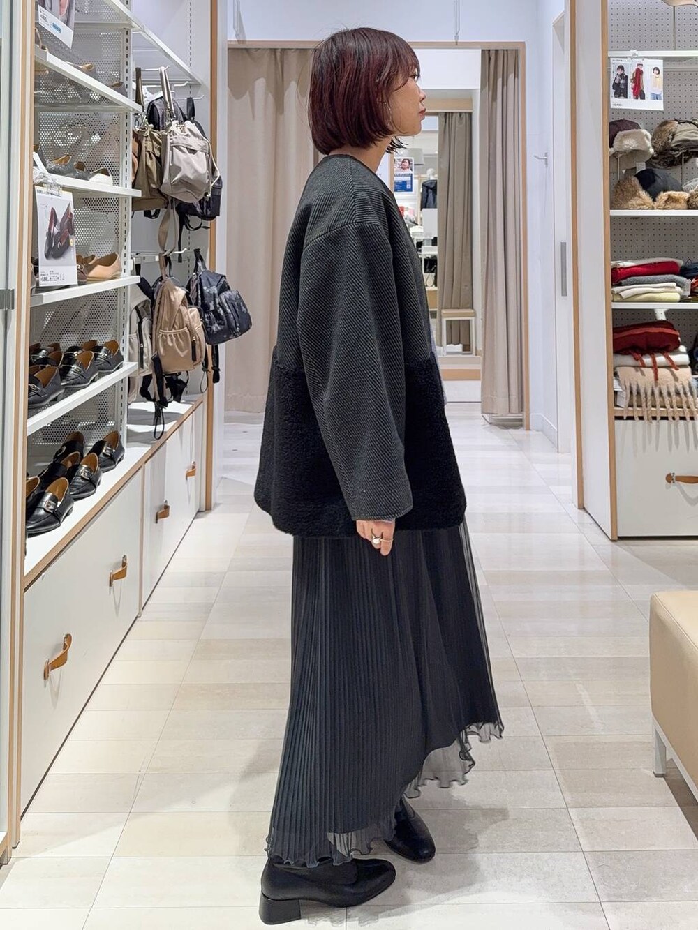 ホワイト系のショルダーバッグ、グレー系のノーカラージャケット、ブラック系のブーツを着用したレディースの秋コーディネートの4枚目の写真