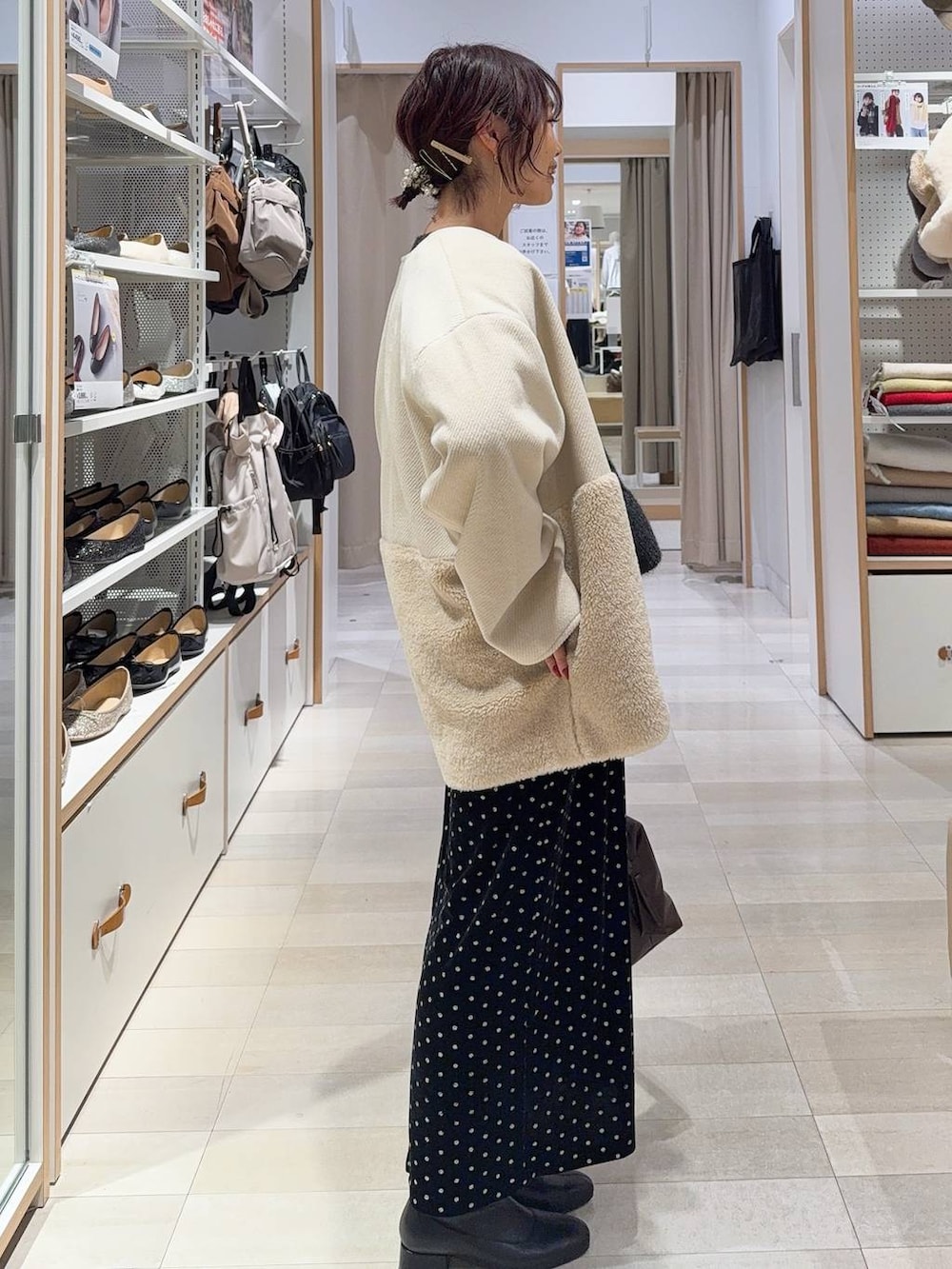 ブラウン系のボストンバッグ、ホワイト系のTシャツ/カットソー、ブラック系のスカートを着用したレディースの秋コーディネートの5枚目の写真