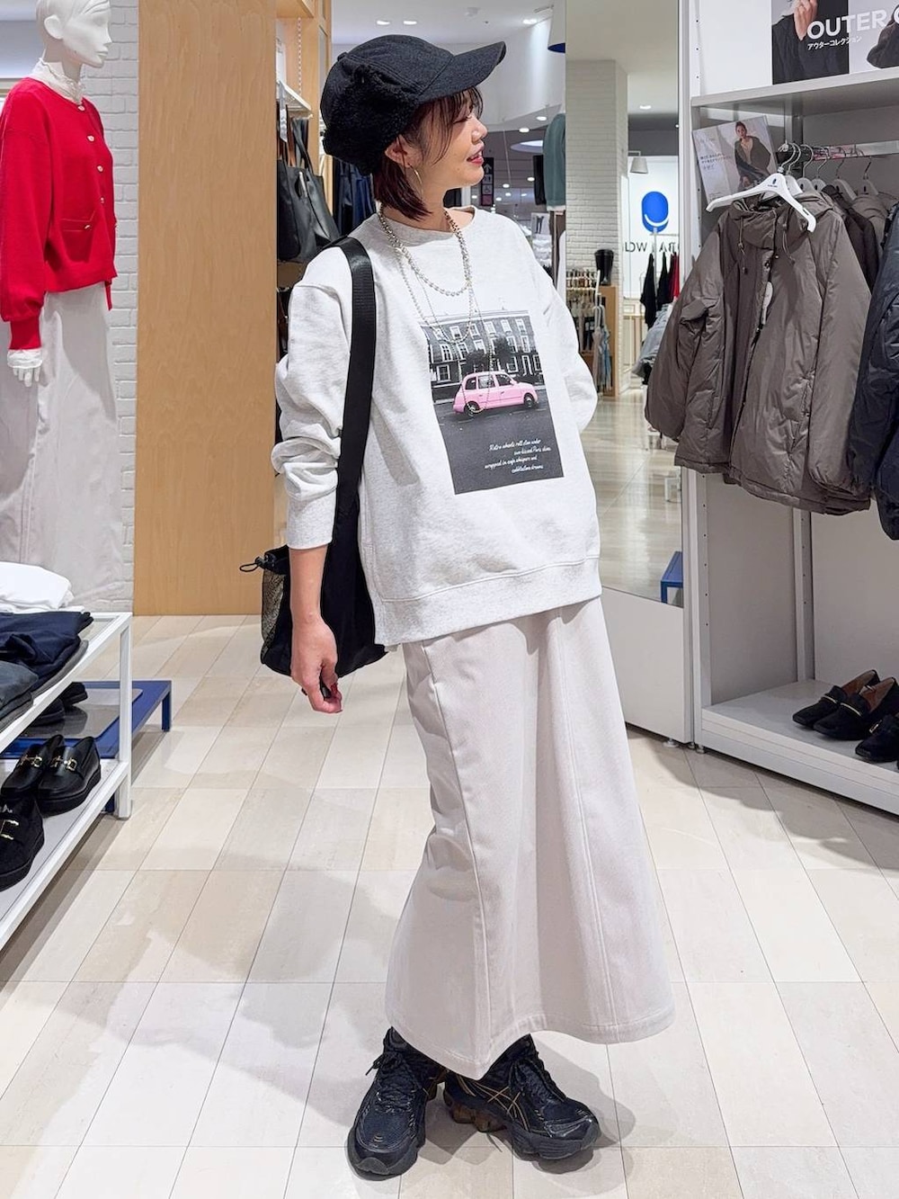 ブラック系のトートバッグ、ブルー系のカーディガン/ボレロ、グレー系のスカートを着用したレディースの秋コーディネートの3枚目の写真