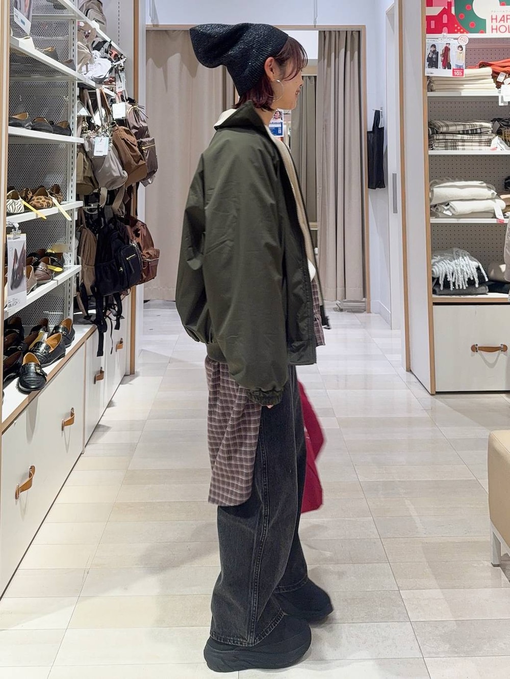 ブラック系のデニムパンツ、ブラウン系のシャツ/ブラウス、レッド系のトートバッグを着用したレディースの冬コーディネートの4枚目の写真