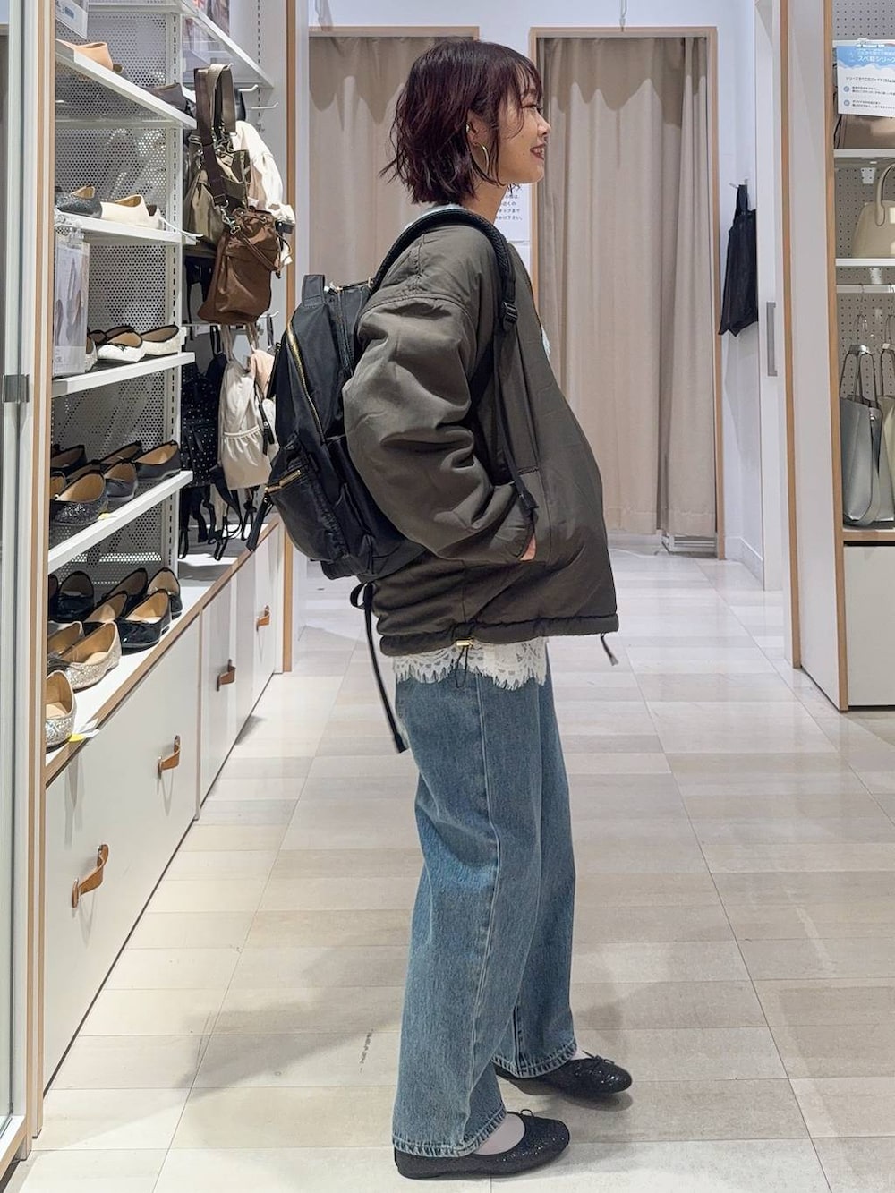 ブラック系のバレエシューズ、グレー系のブルゾン、ブルー系のデニムパンツを着用したレディースの秋コーディネートの6枚目の写真