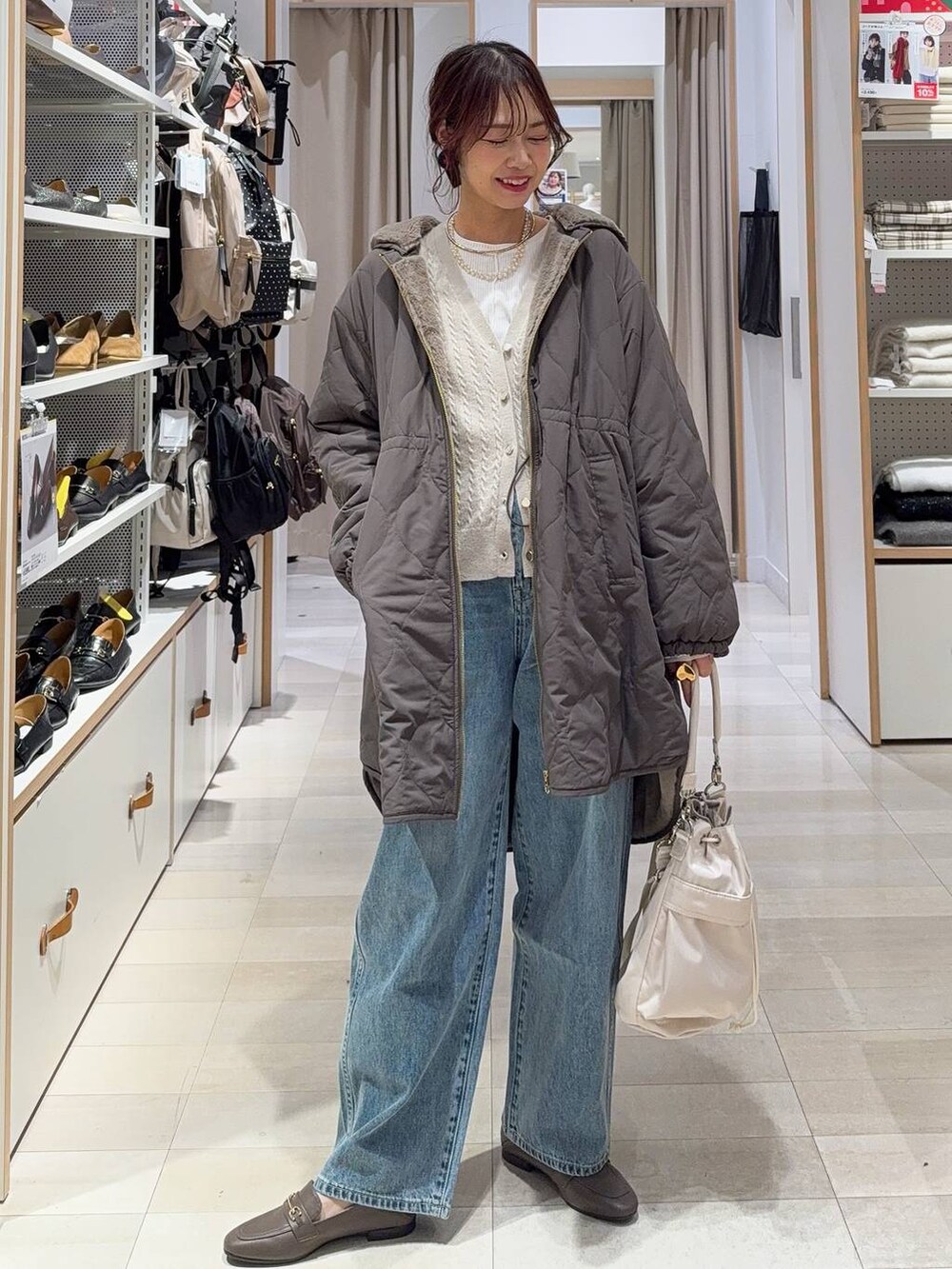 ホワイト系のショルダーバッグ、ブルー系のデニムパンツ、ブラウン系のブルゾンを着用したレディースの冬コーディネートの2枚目の写真