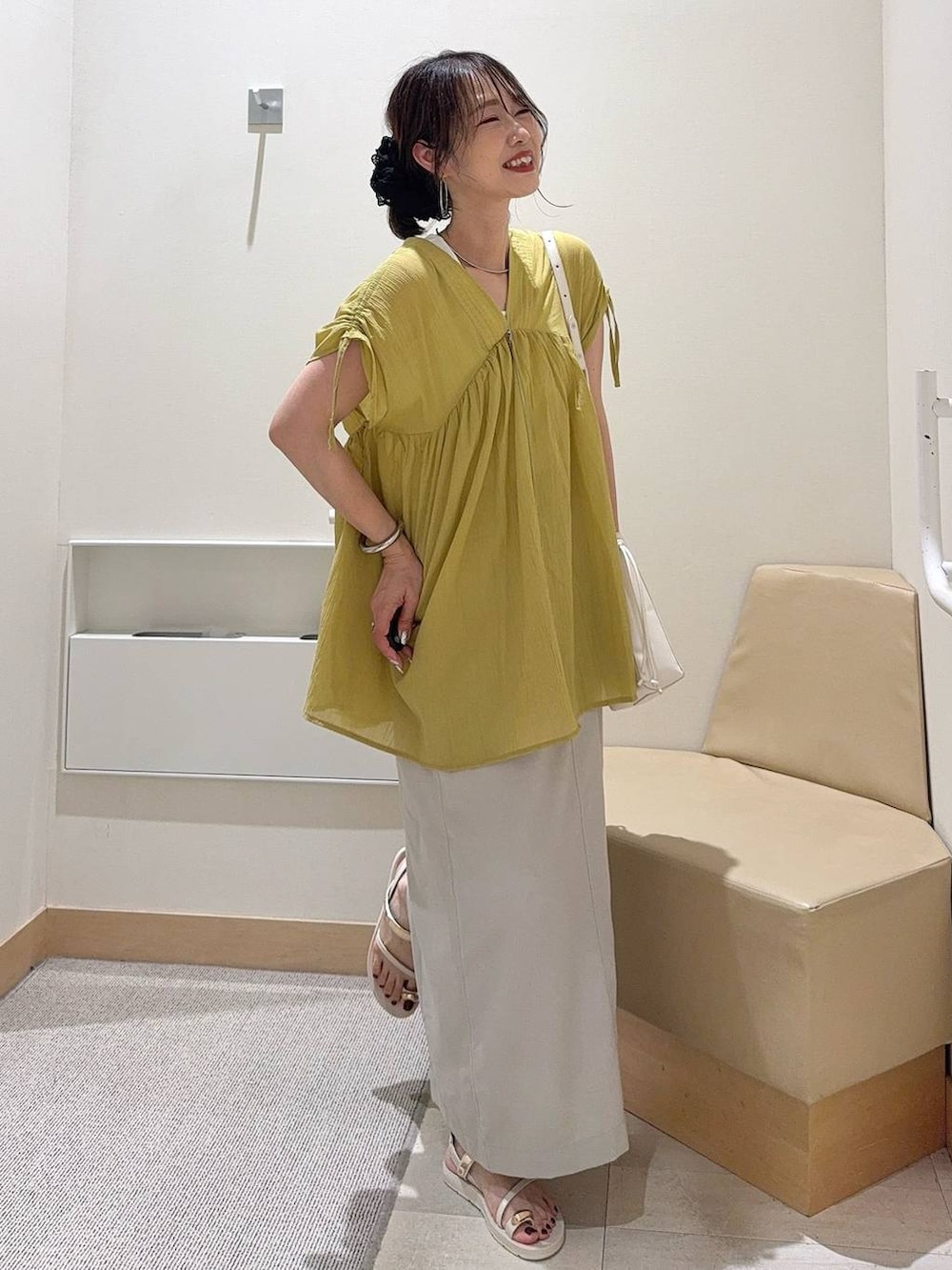 ホワイト系のデニムパンツ、グリーン系のショルダーバッグ、ブラック系のシャツ/ブラウスを着用したレディースの夏コーディネートの3枚目の写真