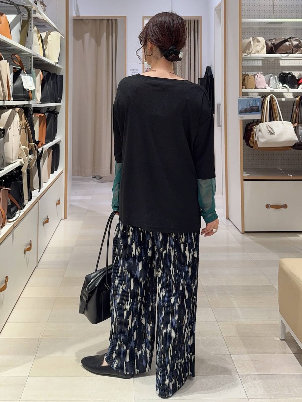 ブラック系のその他シューズ、ブラック系のボストンバッグ、ブルー系のベストを着用したレディースの春コーディネートの7枚目の写真