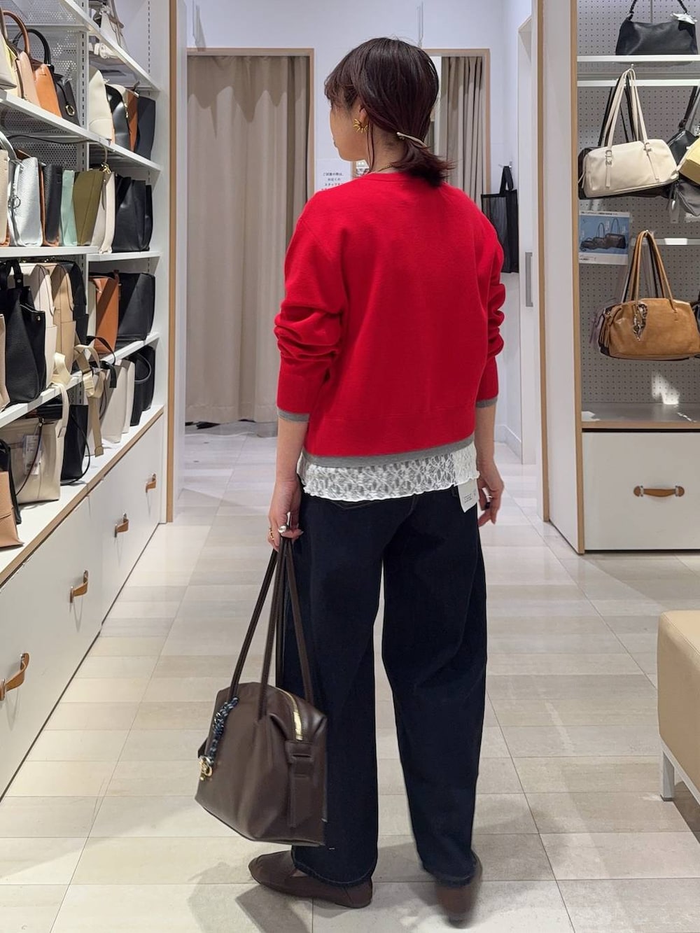 ブラウン系のボストンバッグ、ブルー系のデニムパンツ、レッド系のカーディガン/ボレロを着用したレディースの春コーディネートの9枚目の写真