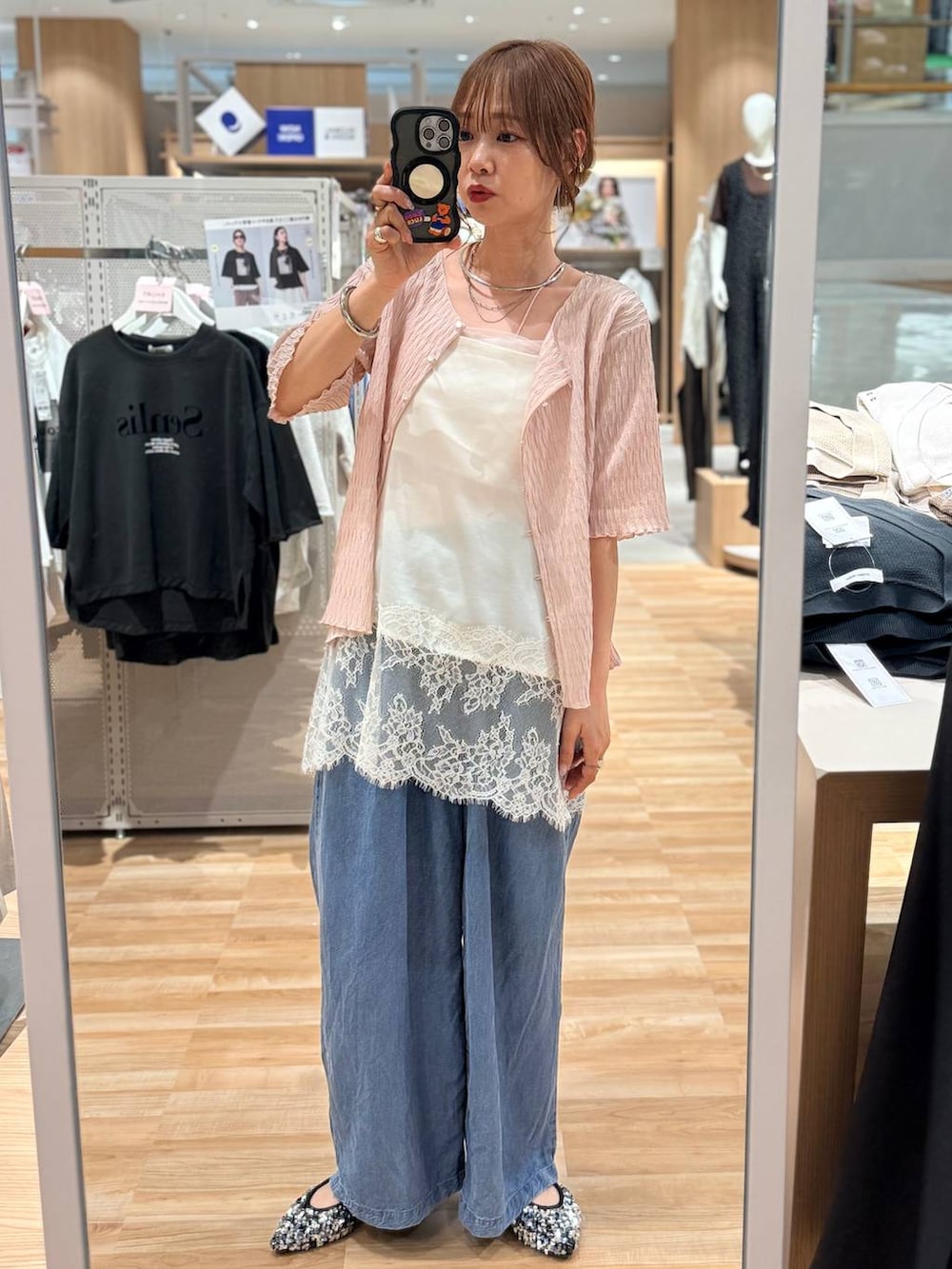 ホワイト系のキャミソール、ブルー系のデニムパンツ、シルバー系のネックレスを着用したレディースの春コーディネートの2枚目の写真