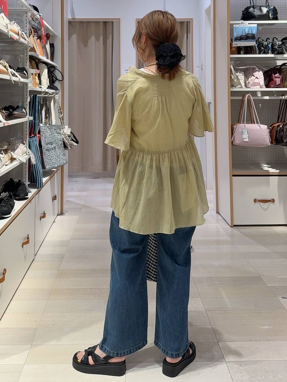 ブルー系のデニムパンツ、ブラウン系のワンピース、ブラック系のサンダルを着用したレディースの夏コーディネートの8枚目の写真