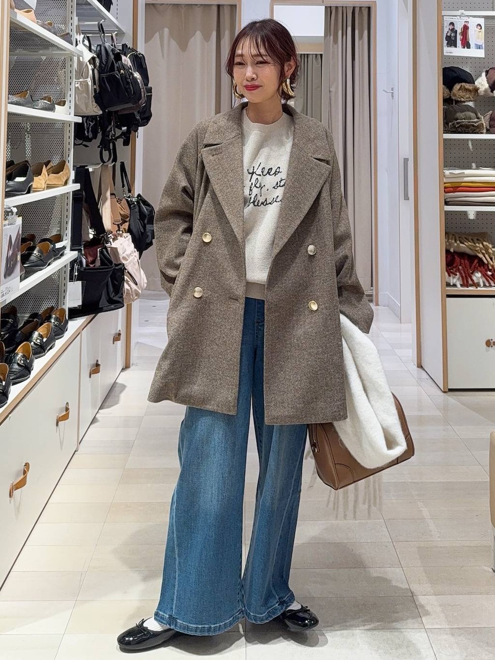 ブラック系のバレエシューズ、ブラウン系のチェスターコート、ブラウン系のニット/セーターを着用したレディースの冬コーディネートの2枚目の写真