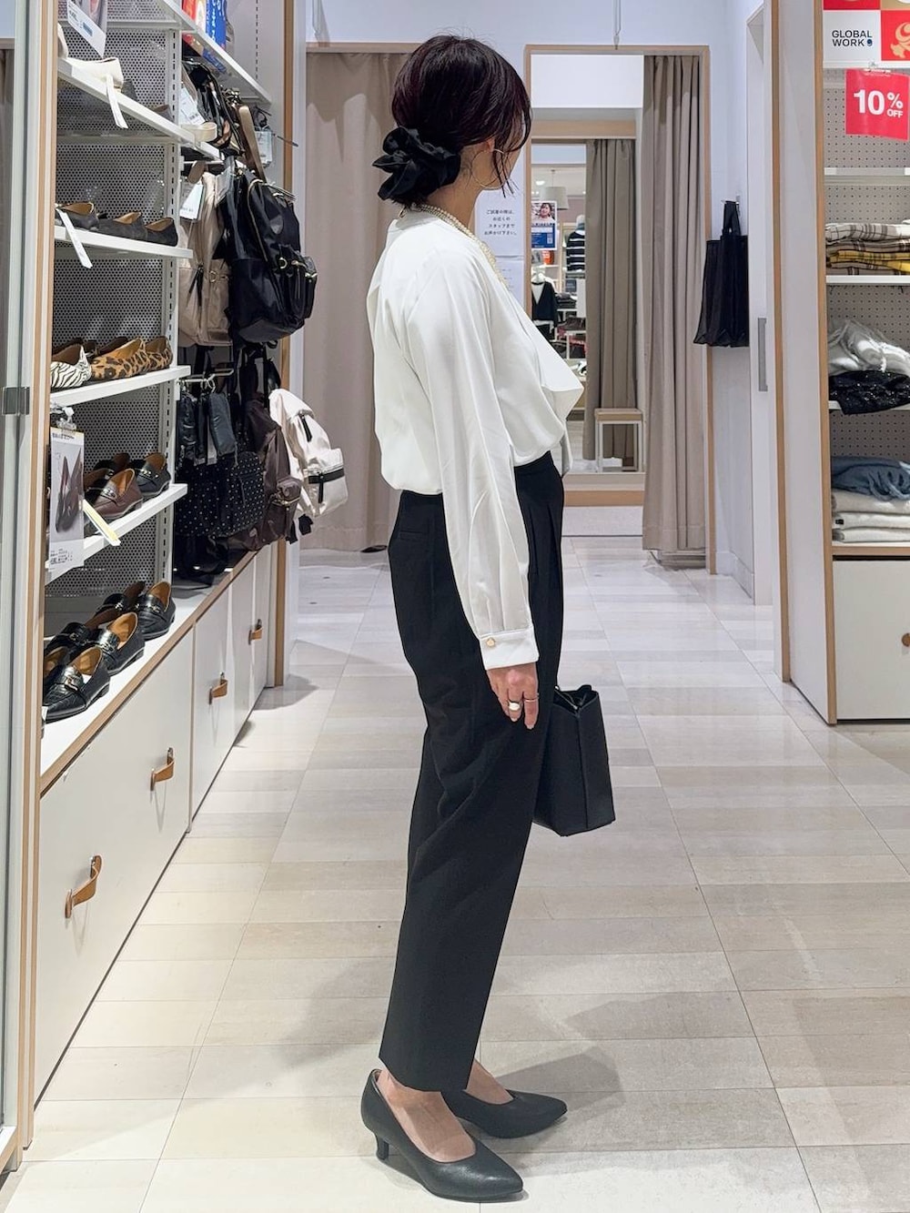 ブラック系のパンプス、ブラック系のスラックス、ホワイト系のシャツ/ブラウスを着用したレディースの冬コーディネートの8枚目の写真