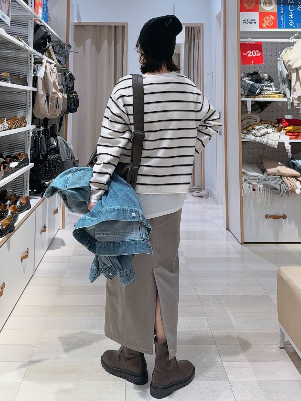 ブラウン系のショルダーバッグ、ブラウン系のスカート、ホワイト系のTシャツ/カットソーを着用したレディースの冬コーディネートの7枚目の写真