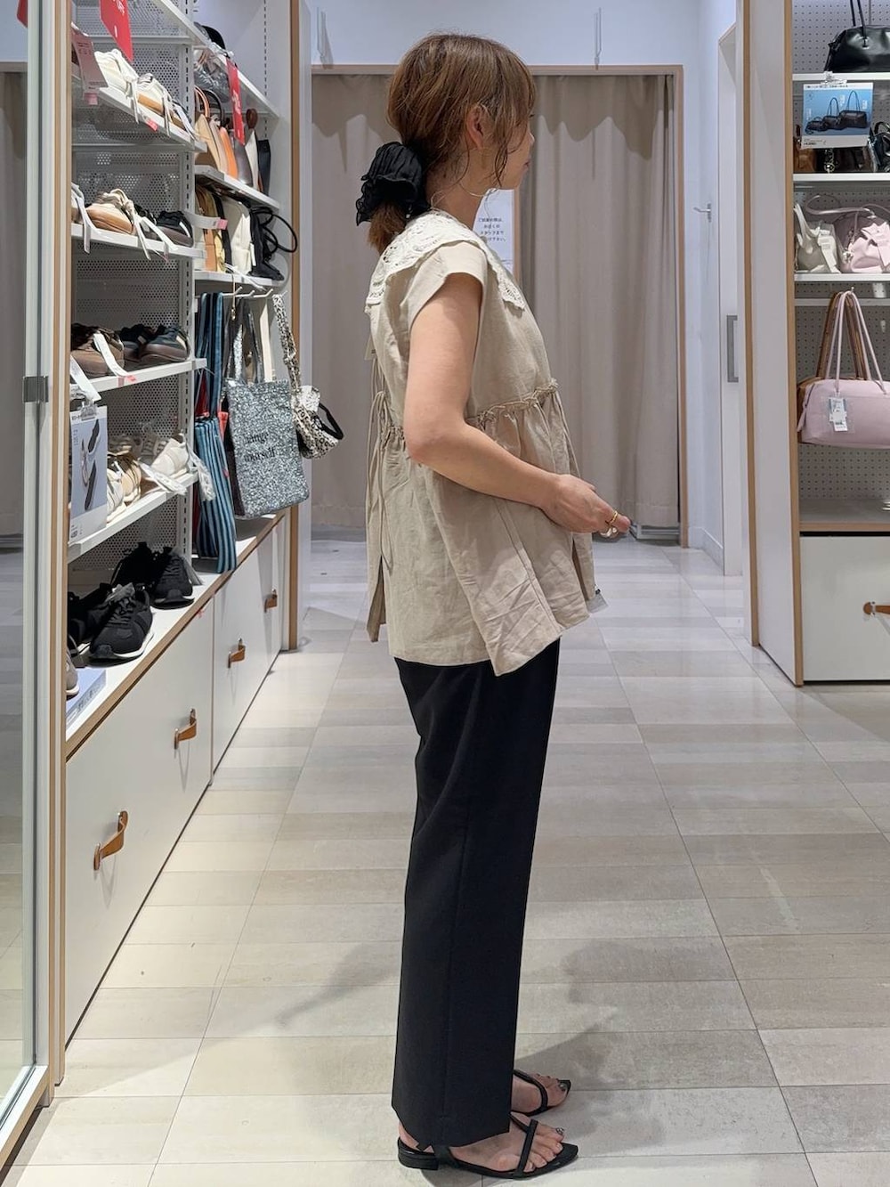 ブラック系のトートバッグ、ブラック系のその他パンツ、ホワイト系のタンクトップを着用したレディースの夏コーディネートの5枚目の写真