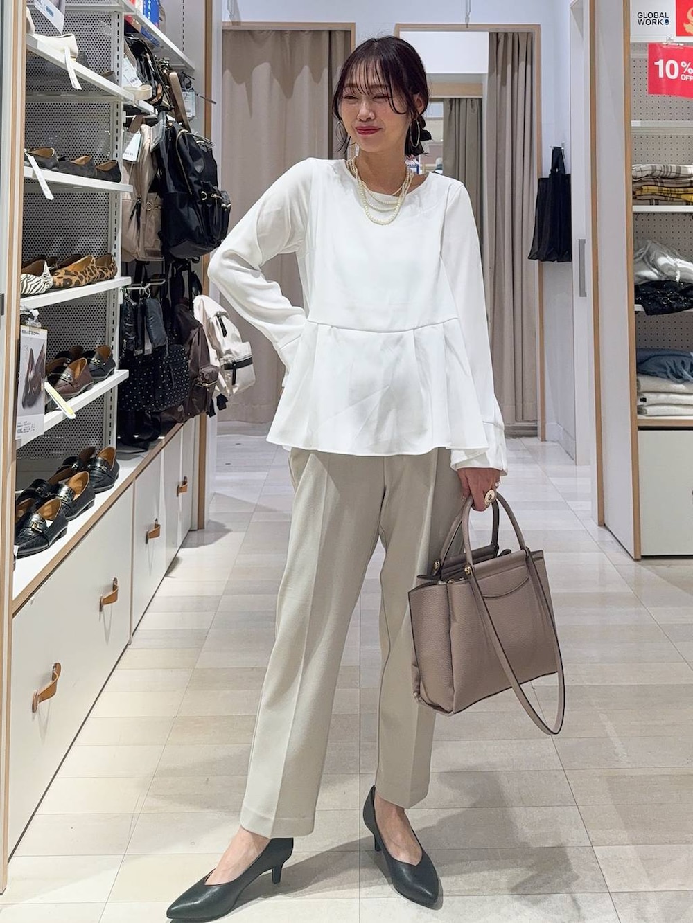 ブラック系のパンプス、ベージュ系のパンツドレス、ベージュ系のトートバッグを着用したレディースの冬コーディネートの2枚目の写真