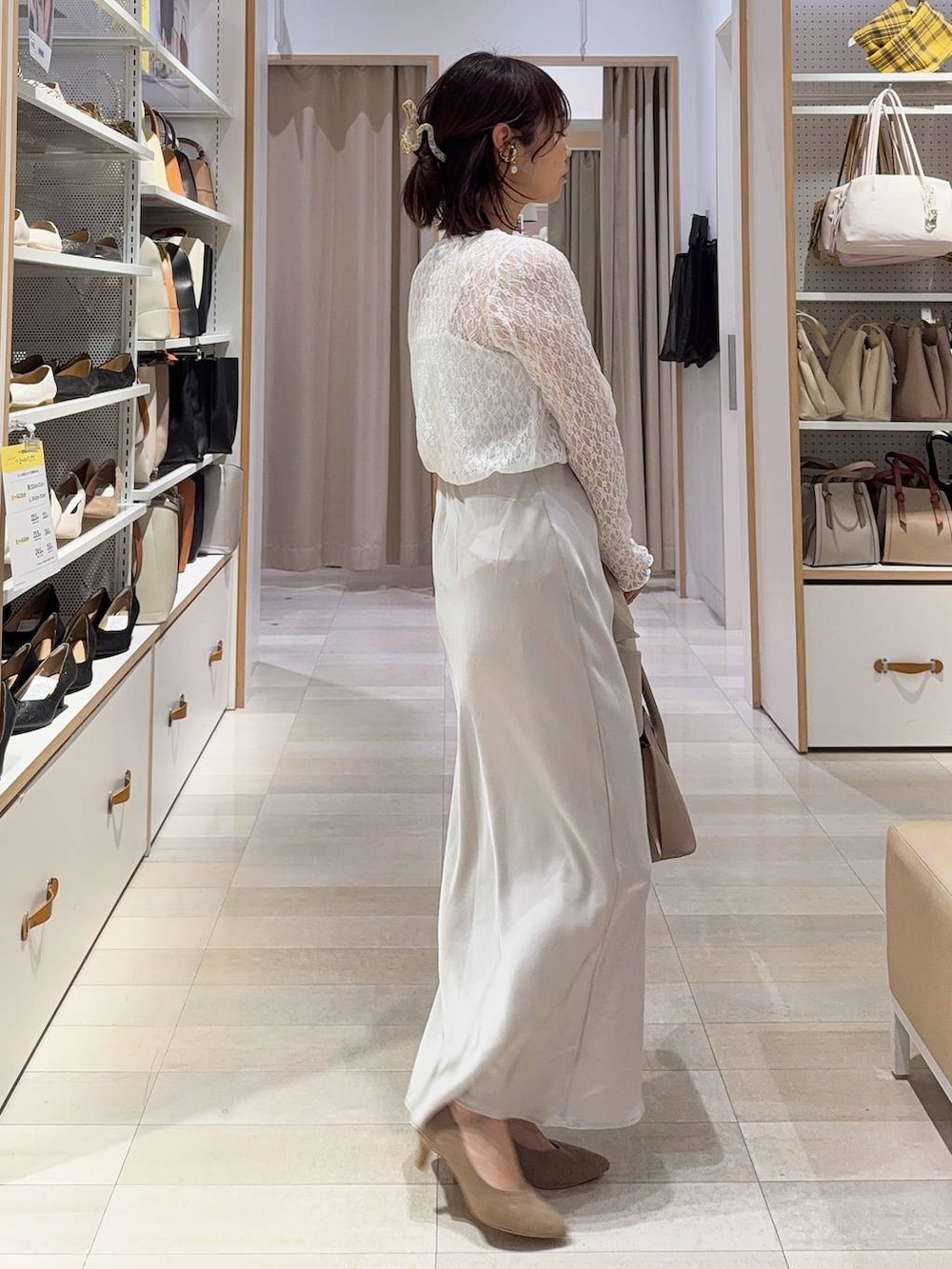 ベージュ系のショルダーバッグ、ベージュ系のパンプス、ホワイト系のキャミソールを着用したレディースの冬コーディネートの7枚目の写真