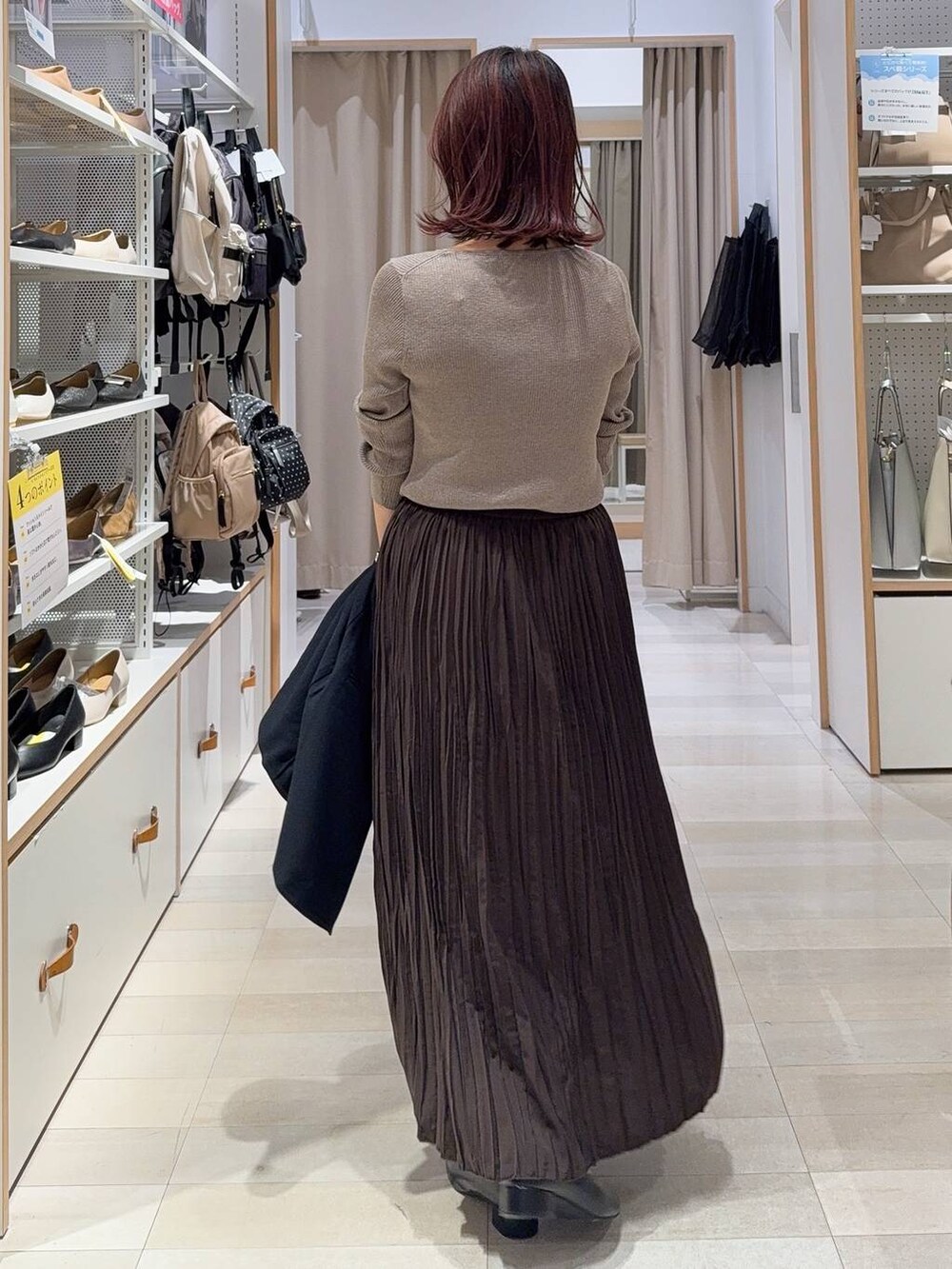 ブラック系のショルダーバッグ、ベージュ系のニット/セーター、ブラウン系のブーツを着用したレディースの秋コーディネートの7枚目の写真