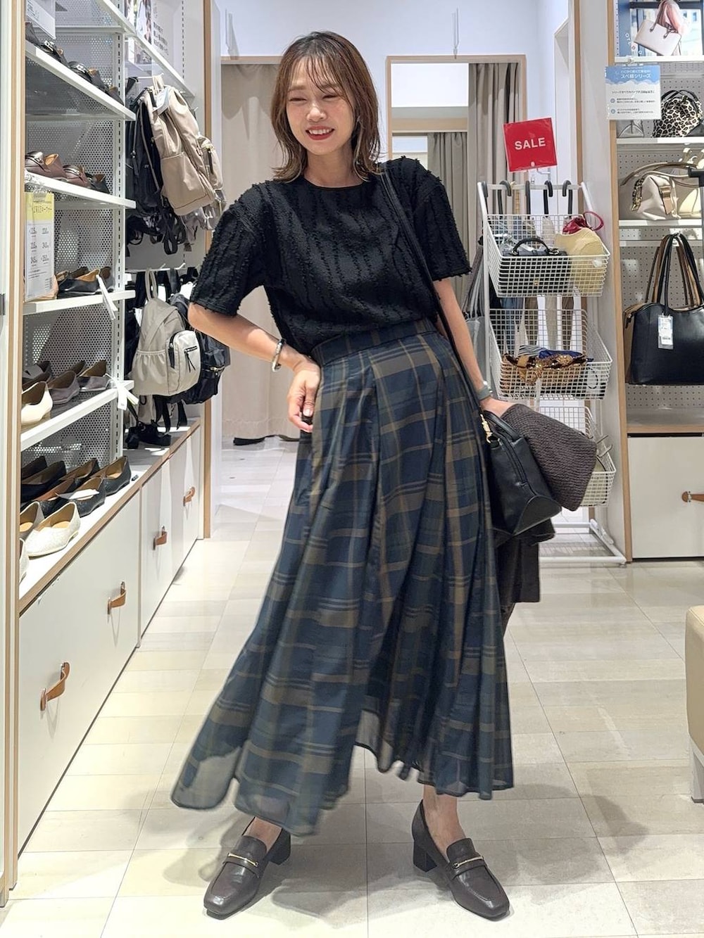 ブラック系のショルダーバッグ、ホワイト系のスニーカー、ブラック系のローファーを着用したレディースの夏コーディネートの3枚目の写真