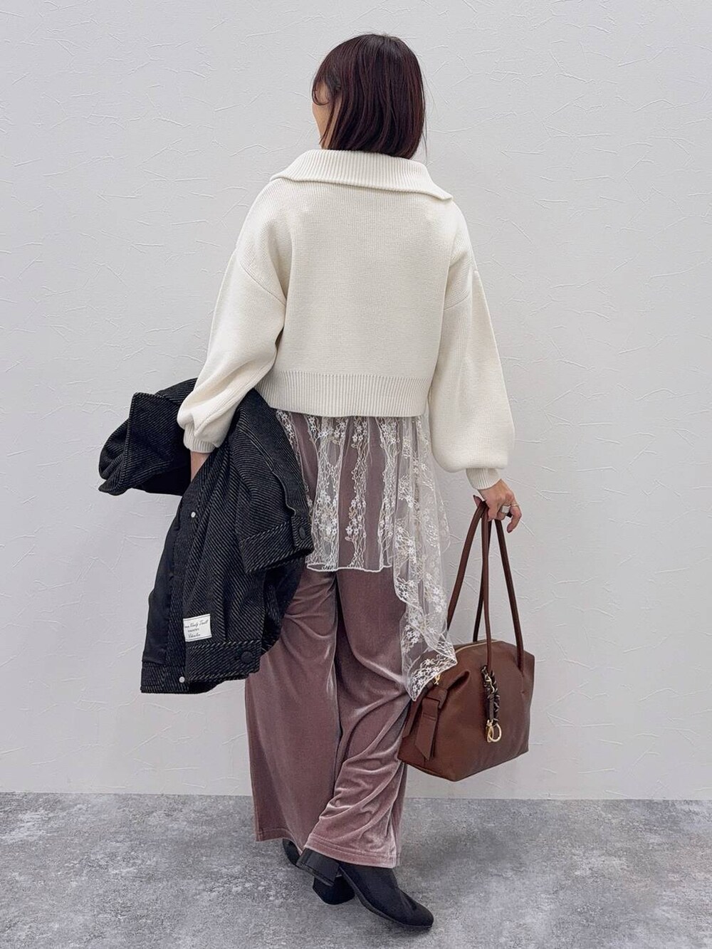 ブラウン系のボストンバッグ、ブラック系のブーツ、ホワイト系のその他トップスを着用したレディースの秋コーディネートの7枚目の写真