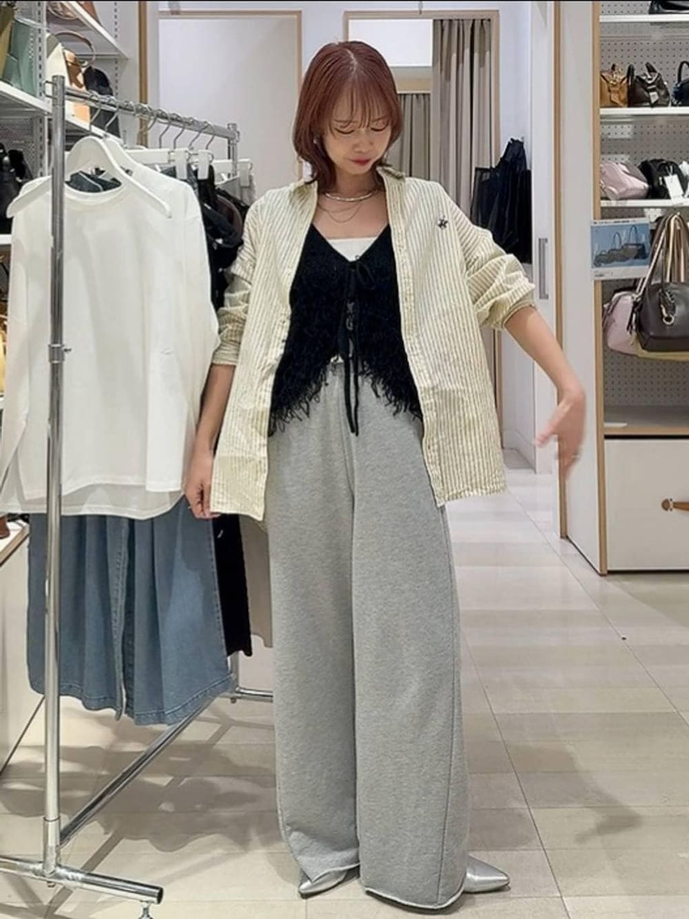 ホワイト系のTシャツ/カットソー、ブラック系のベスト、ブルー系のデニムパンツを着用したレディースの春コーディネートの3枚目の写真