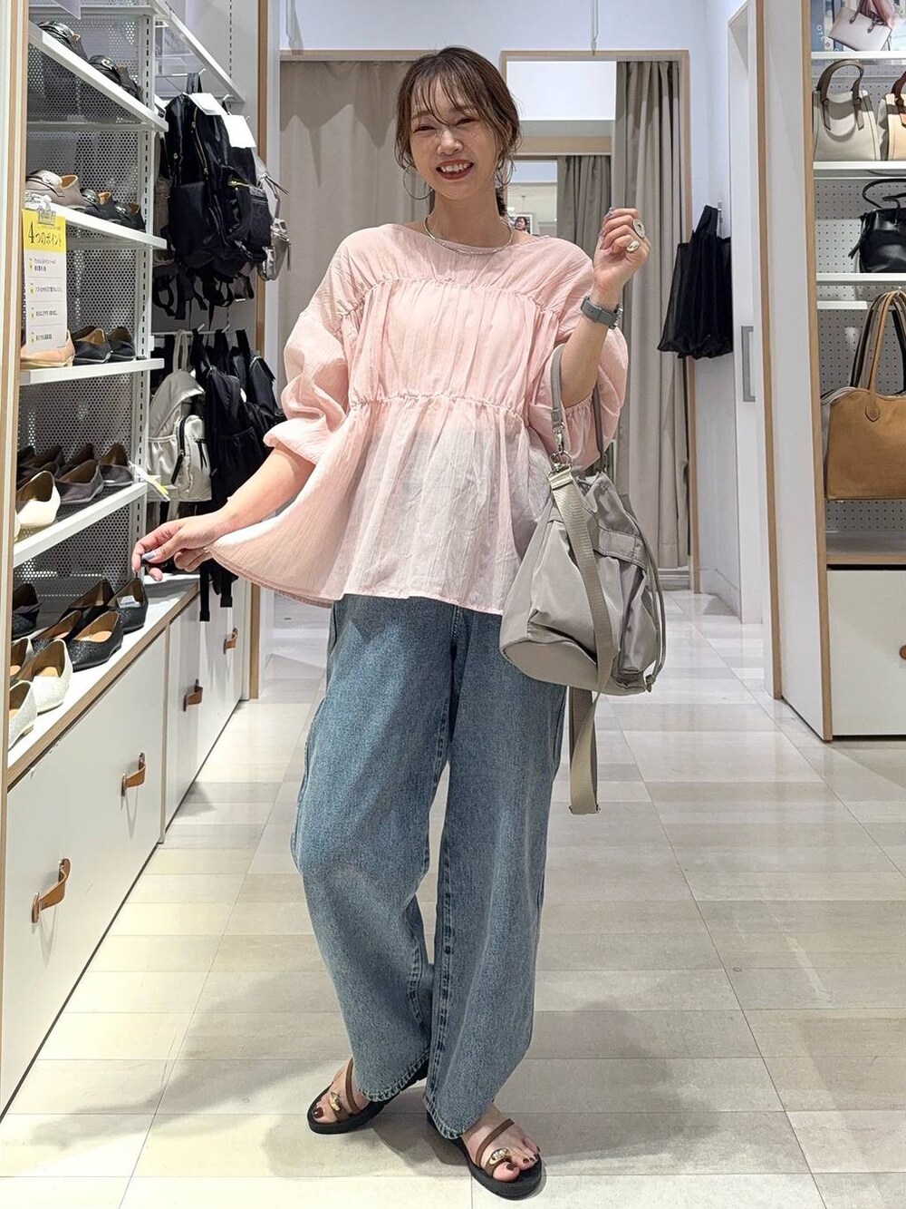 ブルー系のデニムパンツ、ブラック系のボストンバッグ、ブラック系のシャツ/ブラウスを着用したレディースの秋コーディネートの7枚目の写真