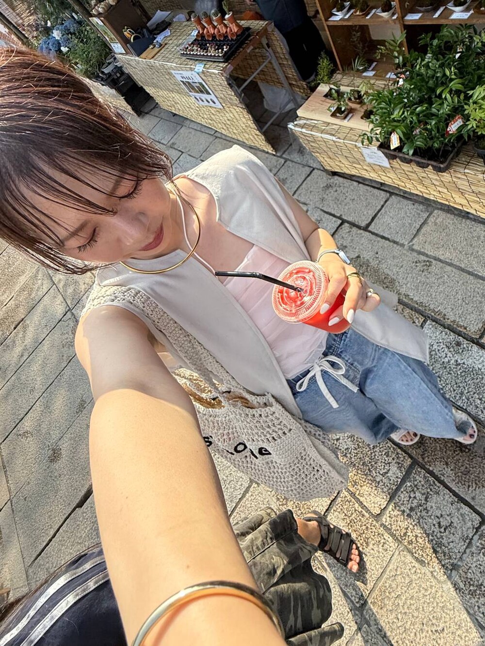 ブルー系のデニムパンツ、ベージュ系のベスト、シルバー系のネックレスを着用したレディースの夏コーディネートの2枚目の写真