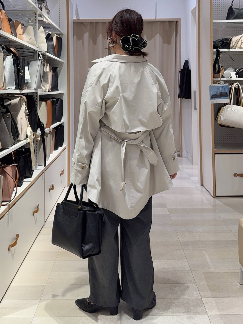 ベージュ系のトレンチコート、ブラック系のトートバッグ、グレー系のその他パンツを着用したレディースの春コーディネートの5枚目の写真