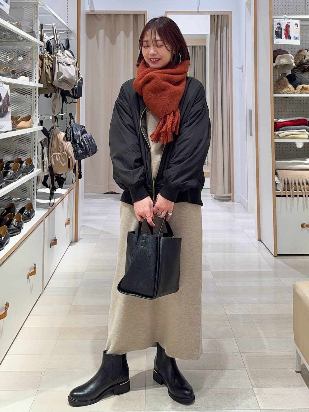 ブラック系のキャミソール、ブラック系のブルゾン、ブラック系のトートバッグを着用したレディースの秋コーディネートの3枚目の写真