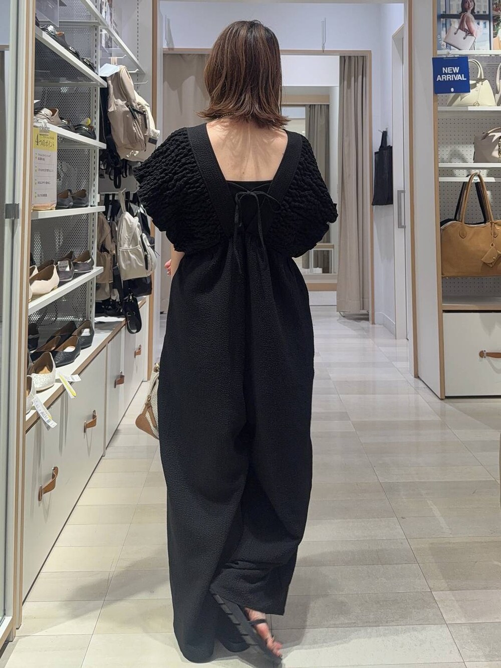 ホワイト系のショルダーバッグ、ブラック系のキャミソール、ブラック系のサンダルを着用したレディースの夏コーディネートの3枚目の写真