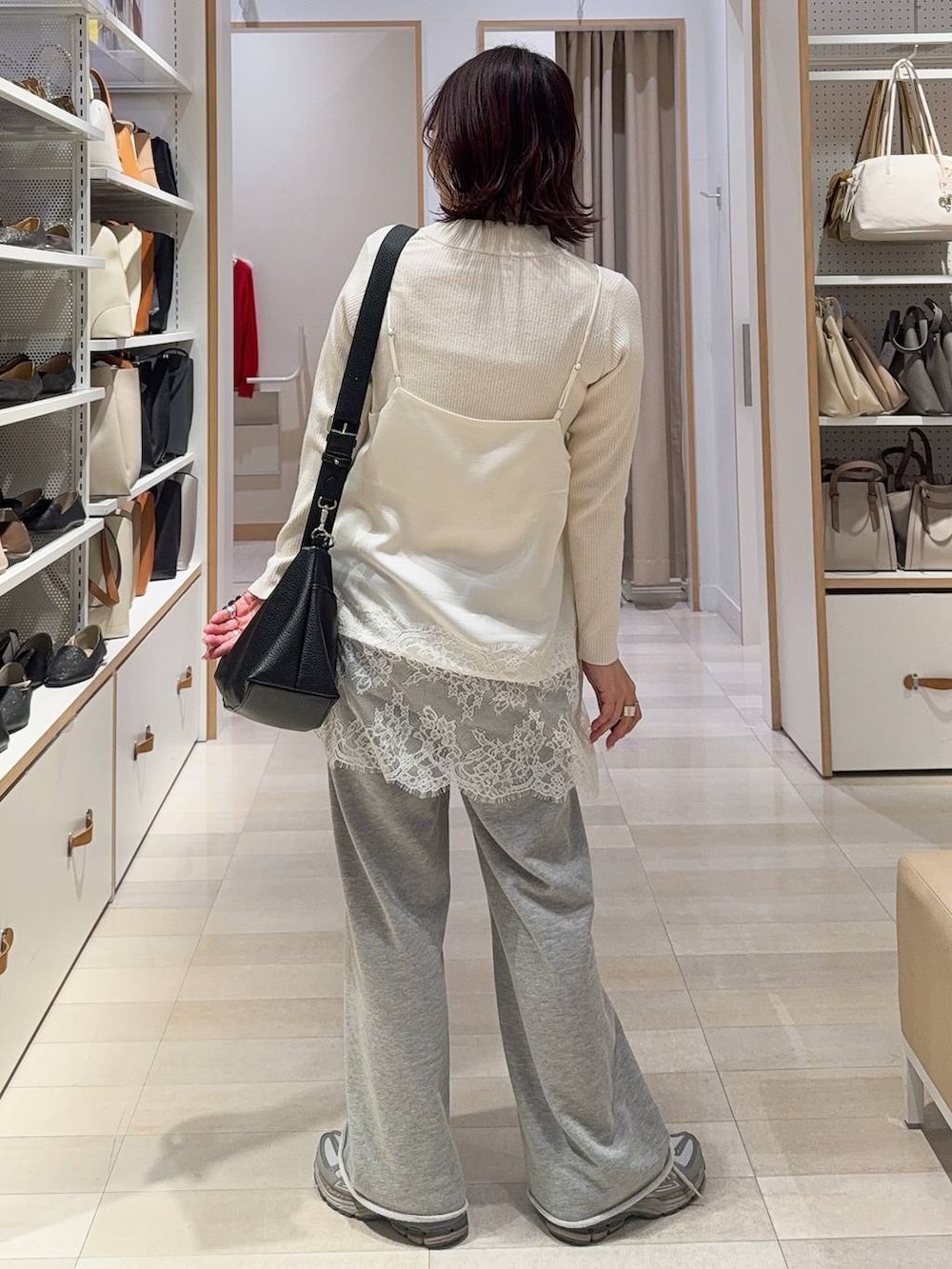 ホワイト系のニット/セーター、グレー系のスウェットパンツを着用したレディースの冬コーディネートの9枚目の写真