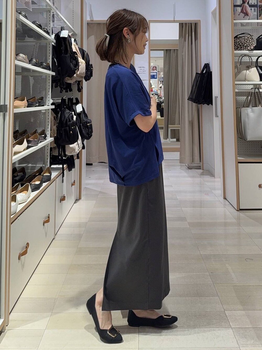 ホワイト系のショルダーバッグ、ブラック系のパンプス、グレー系のスカートを着用したレディースの夏コーディネートの6枚目の写真