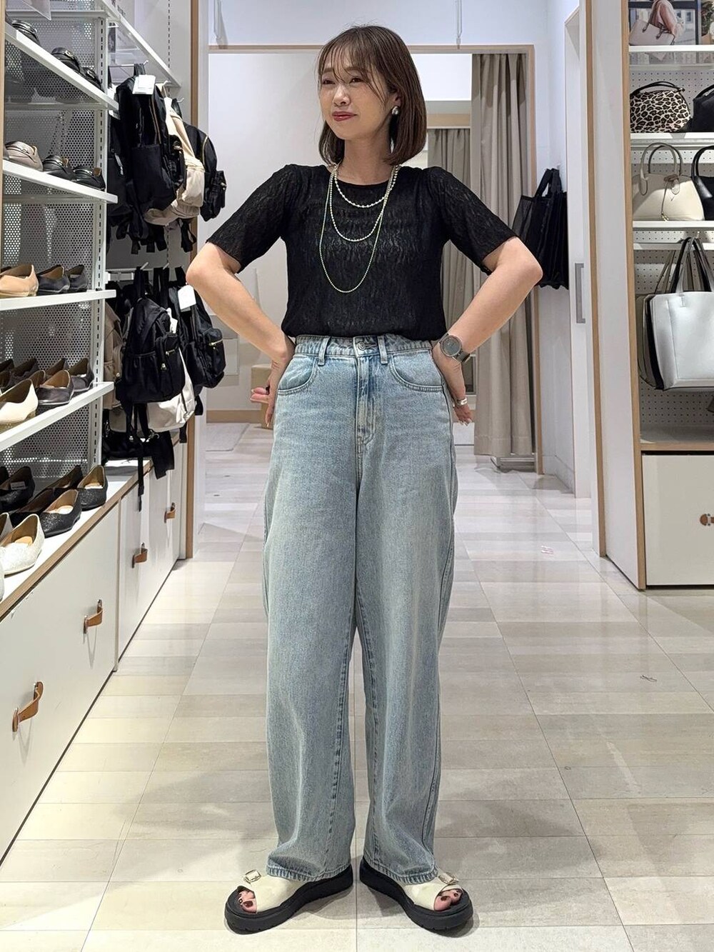 ブルー系のデニムパンツ、ホワイト系のキャミソール、ブラック系のキャミソールを着用したレディースの夏コーディネートの4枚目の写真