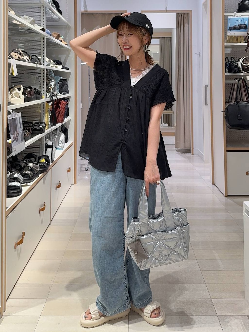 ブルー系のデニムパンツ、ブラウン系のボストンバッグ、レッド系のシャツ/ブラウスを着用したレディースの夏コーディネートの5枚目の写真