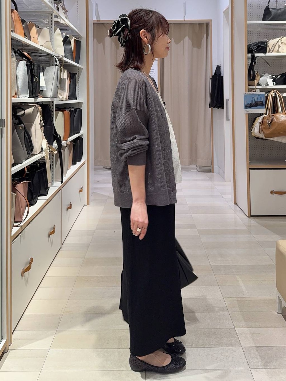 ブラック系のバレエシューズ、ブラック系のスカート、シルバー系のネックレスを着用したレディースの春コーディネートの3枚目の写真