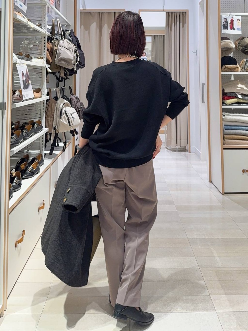 グリーン系のショルダーバッグ、ブラック系のチェスターコート、ブラック系のスウェットを着用したレディースの秋コーディネートの7枚目の写真