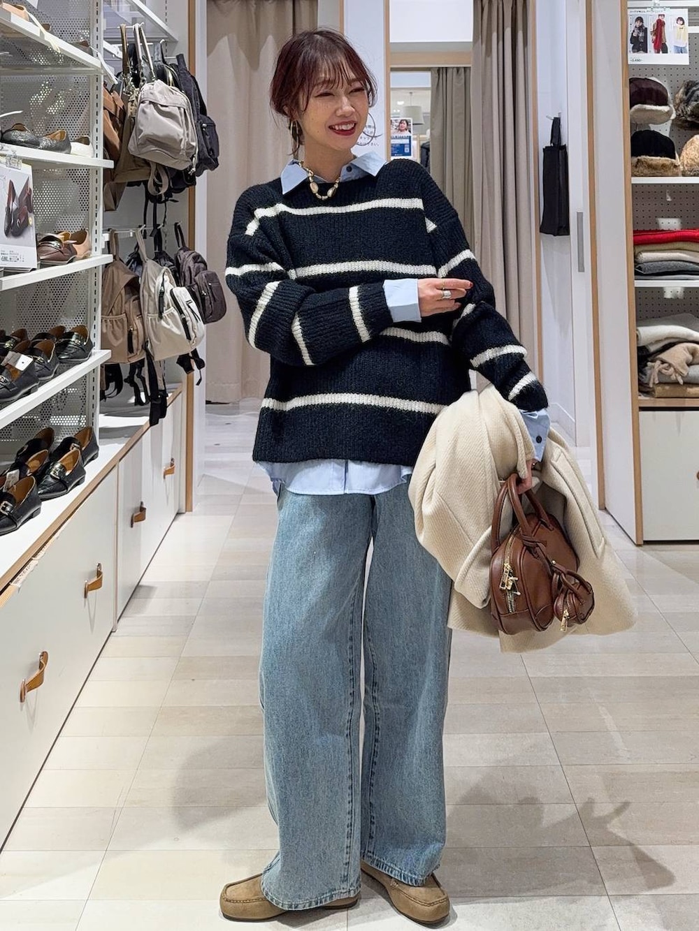 ブラウン系のスカート、ブラウン系のトートバッグ、ホワイト系のTシャツ/カットソーを着用したレディースの冬コーディネートの3枚目の写真