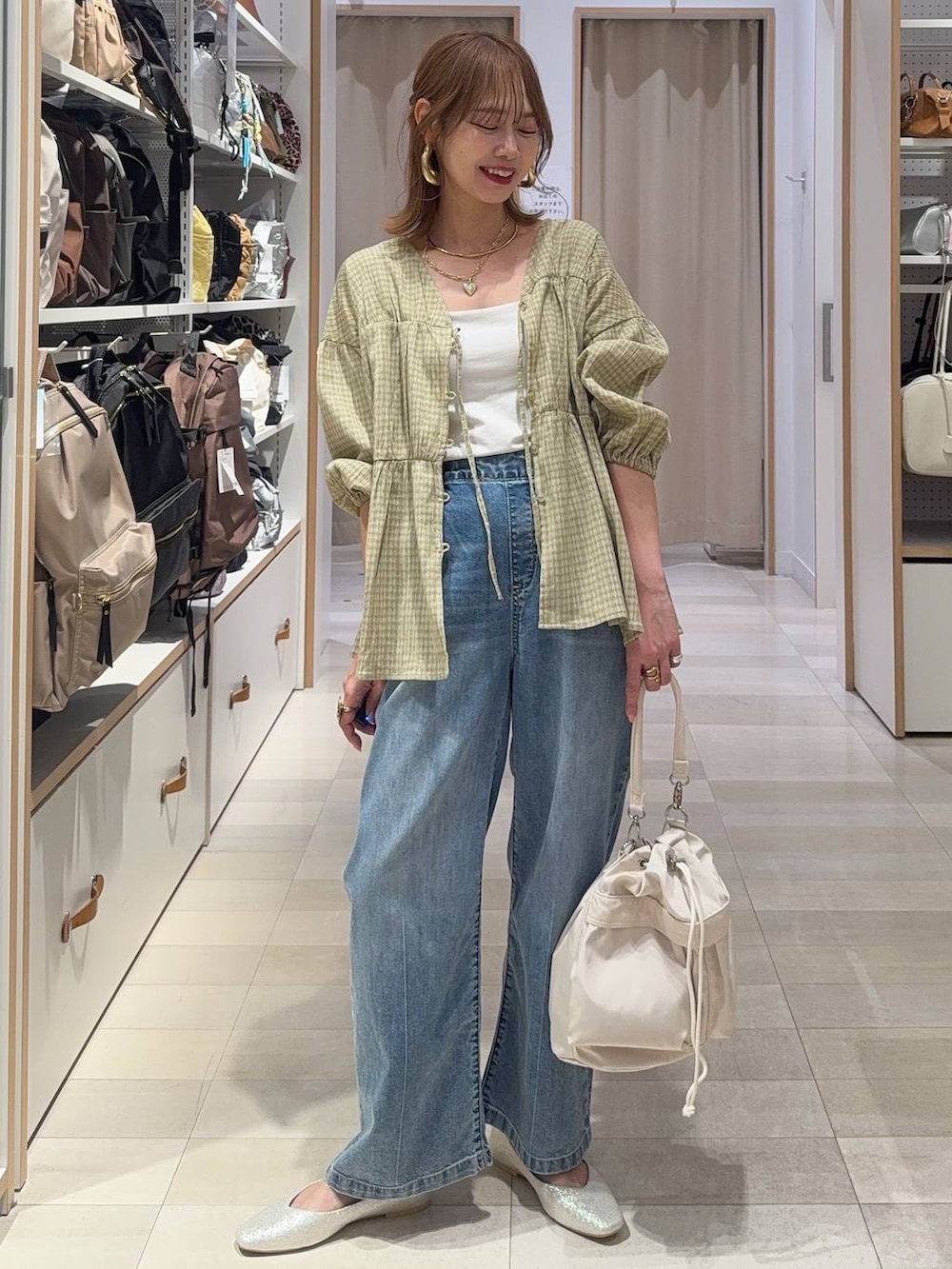 ベージュ系のパンプス、ホワイト系のショルダーバッグ、ホワイト系のキャミソールを着用したレディースの春コーディネートの2枚目の写真