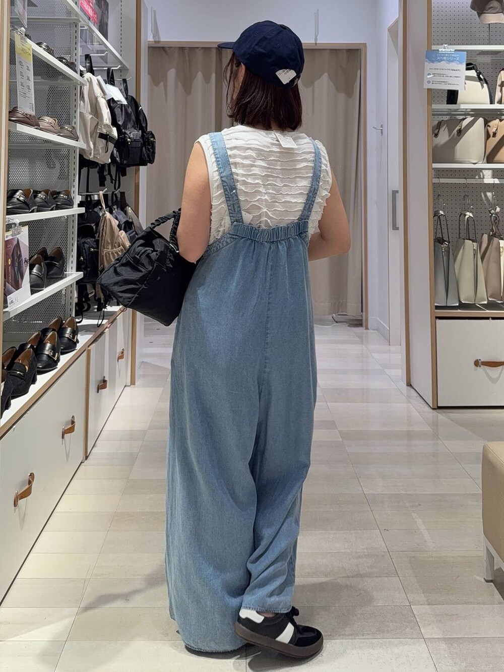 ブラック系のスニーカー、ブラック系のショルダーバッグ、ホワイト系のTシャツ/カットソーを着用したレディースの秋コーディネートの7枚目の写真