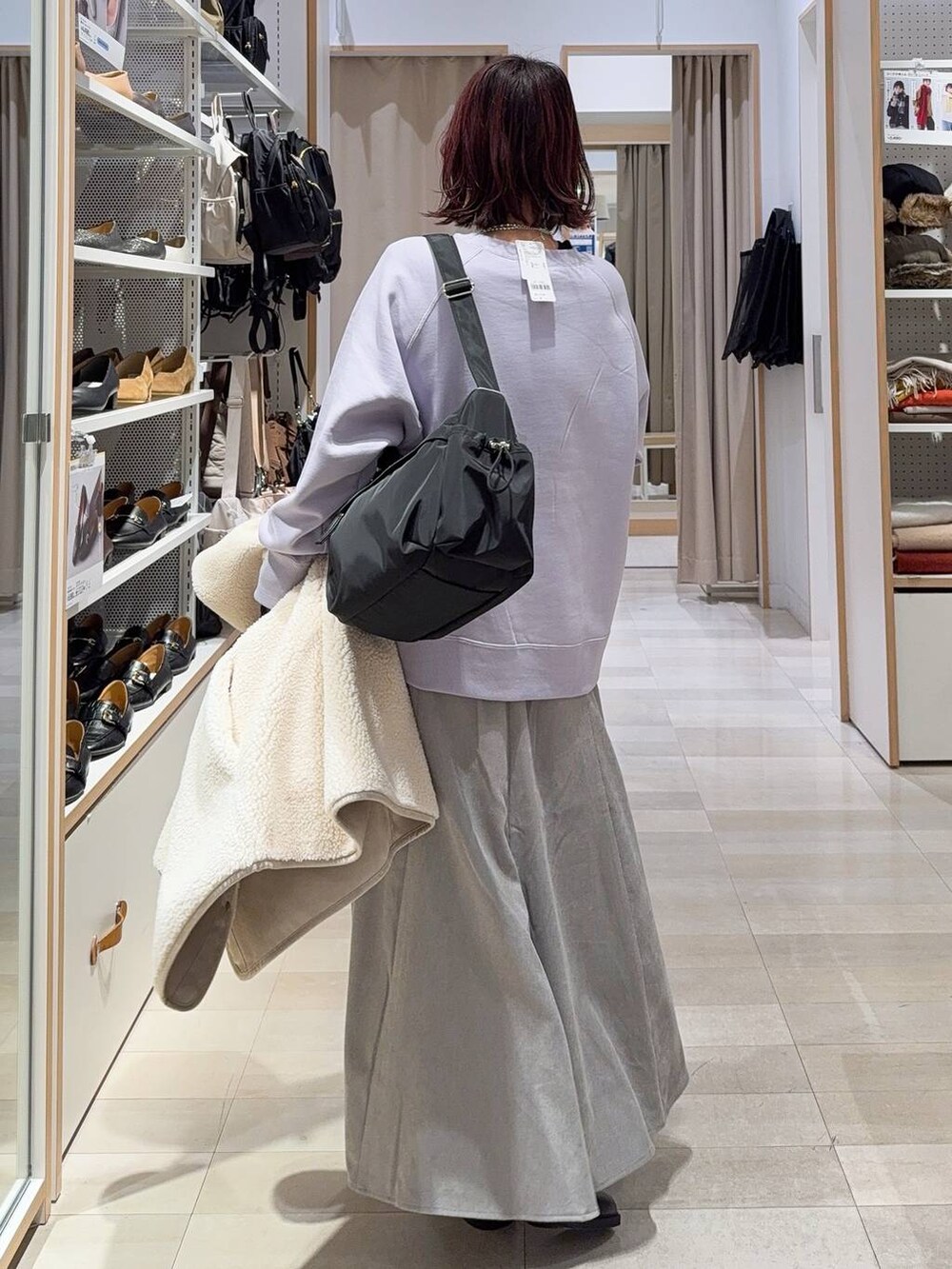 ブラック系のショルダーバッグ、グレー系のスカート、パープル系のスウェットを着用したレディースの冬コーディネートの6枚目の写真