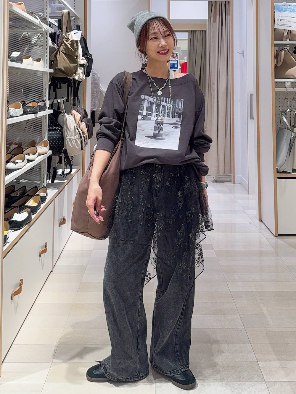 グレー系のスウェット、ブラック系のデニムパンツ、ブラック系のその他トップスを着用したレディースの秋コーディネートの3枚目の写真