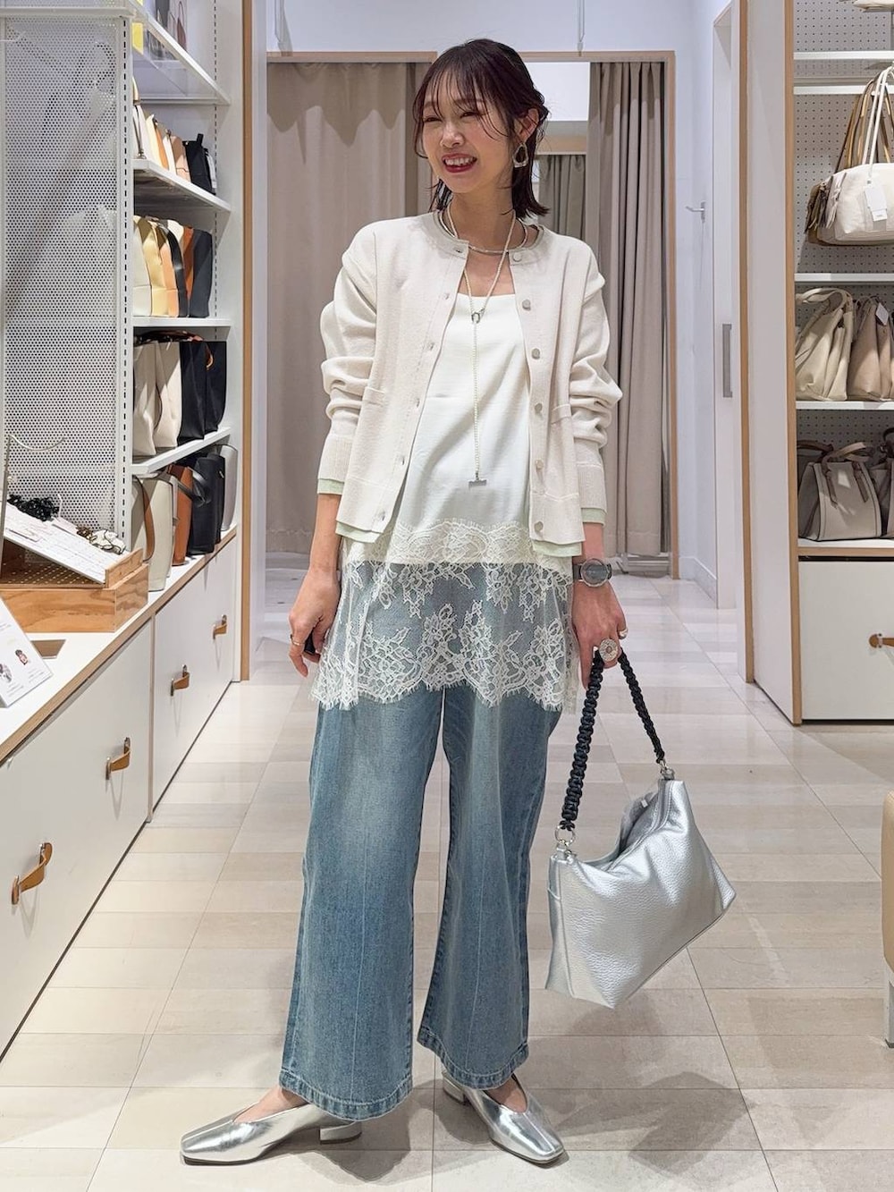 その他のパンプス、ベージュ系のボストンバッグ、ブルー系のデニムパンツを着用したレディースの冬コーディネートの3枚目の写真