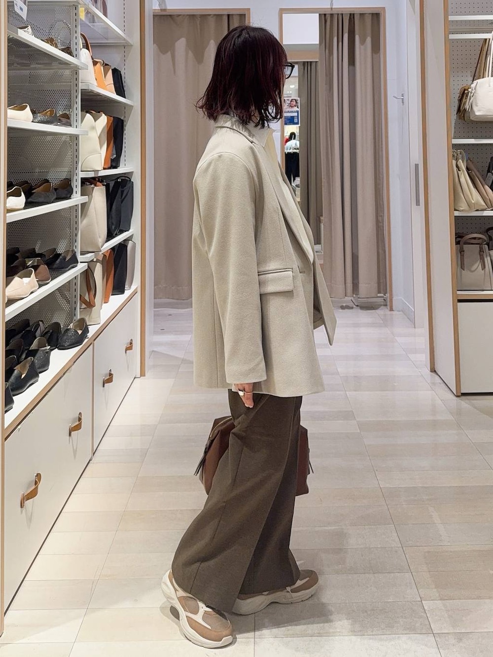 ブラウン系のボストンバッグ、ブラウン系のその他パンツ、ブラウン系のその他シューズを着用したレディースの冬コーディネートの4枚目の写真