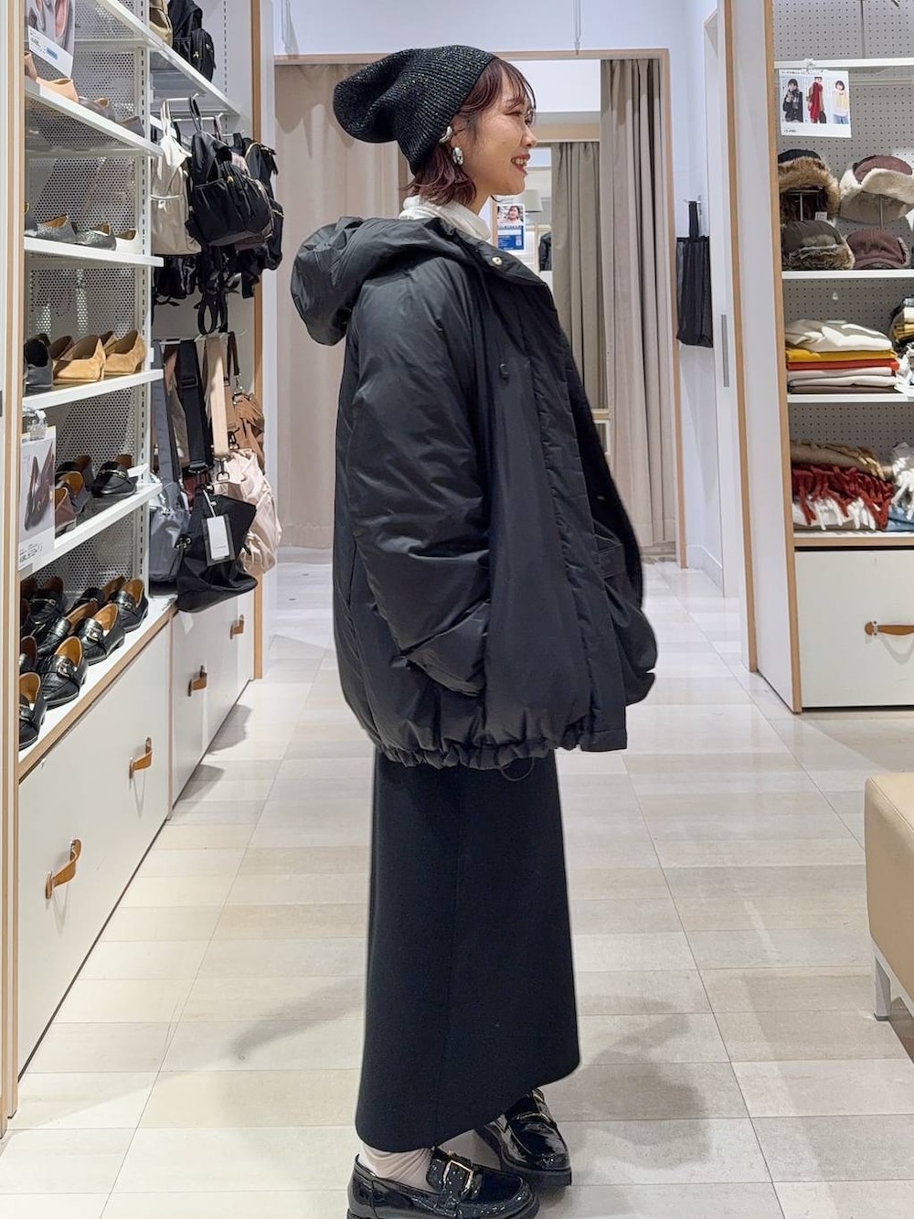 ブラック系のローファー、ブラック系のショルダーバッグ、ブラック系のダウンジャケット/コートを着用したレディースの冬コーディネートの6枚目の写真