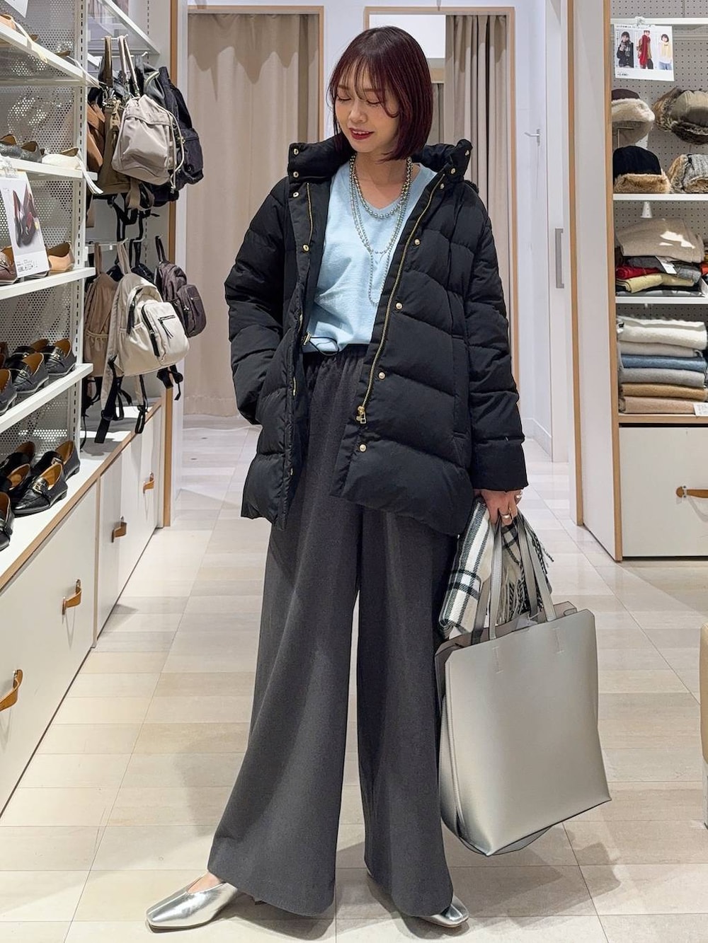 ブラック系のダウンジャケット/コート、ベージュ系のデニムパンツ、ホワイト系のTシャツ/カットソーを着用したレディースの冬コーディネートの3枚目の写真