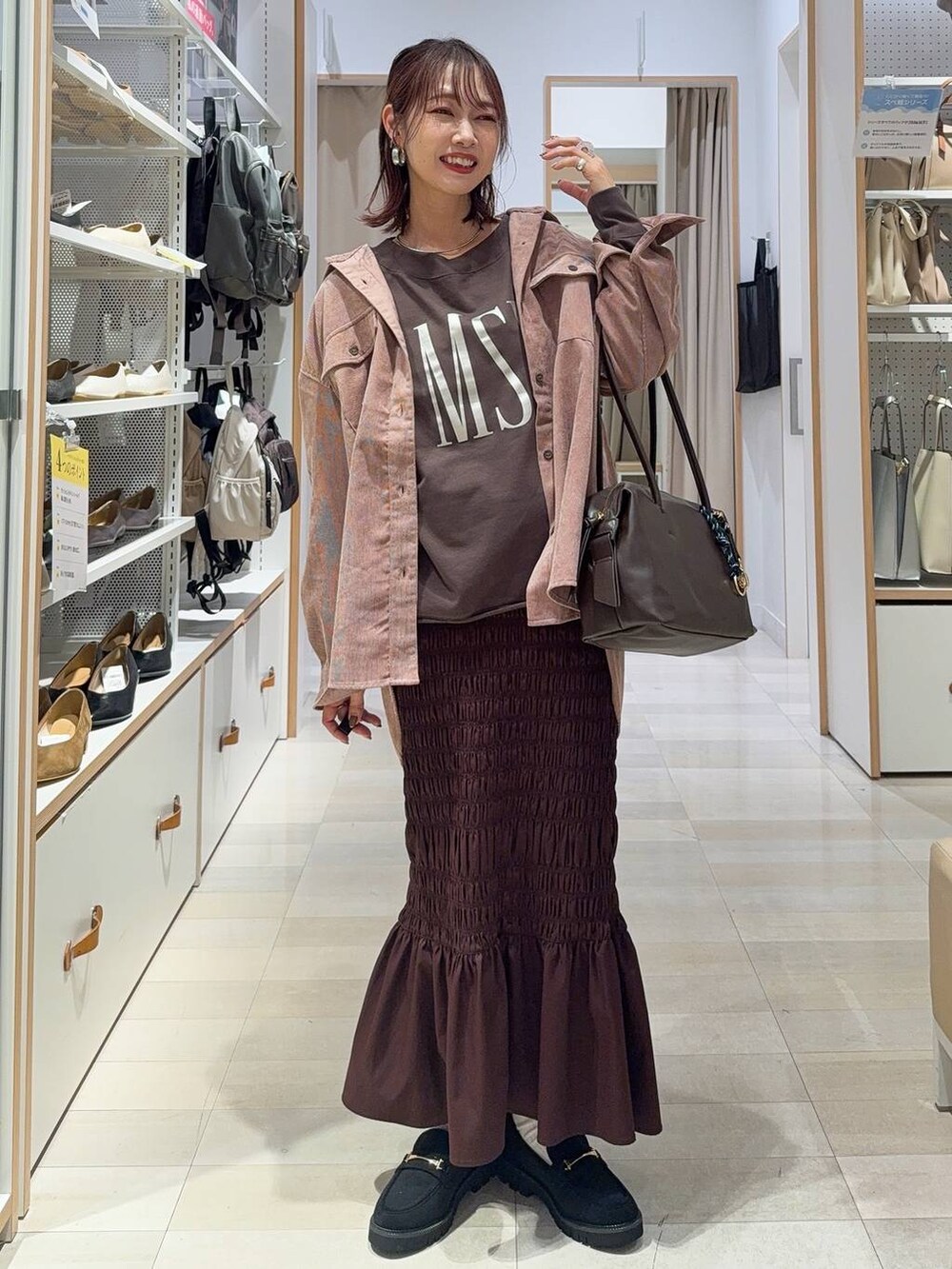 ブラック系のバックパック/リュック、ブラック系のスニーカー、グレー系のスカートを着用したレディースの秋コーディネートの5枚目の写真