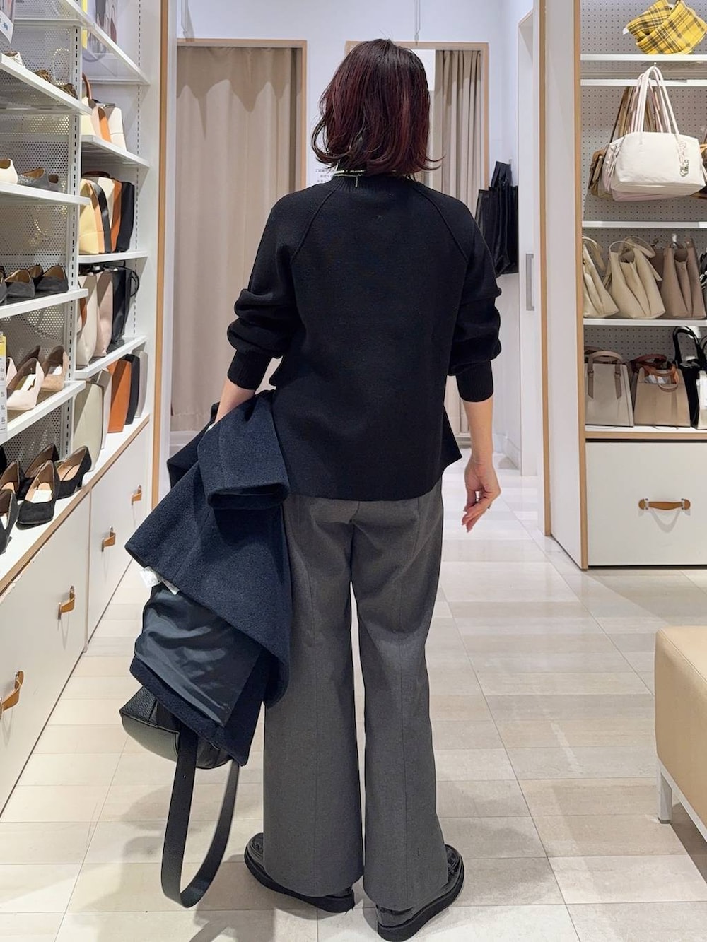 ブラック系のローファー、ブルー系のチェスターコート、グレー系のその他パンツを着用したレディースの冬コーディネートの9枚目の写真