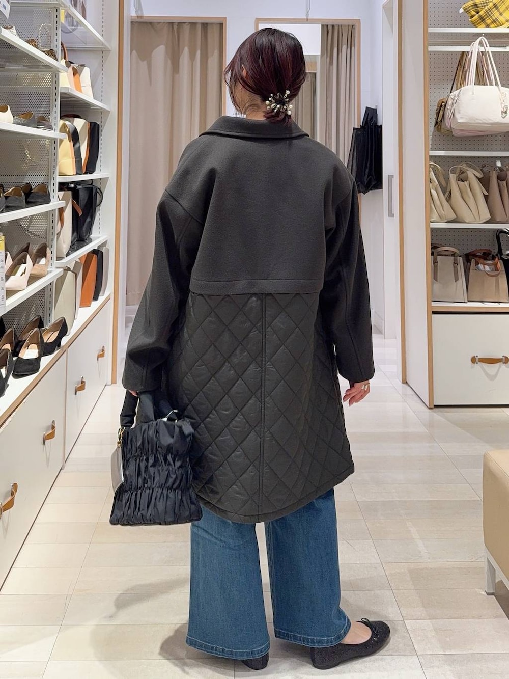 ブラック系のバレエシューズ、ブラウン系のステンカラーコート、ブルー系のデニムパンツを着用したレディースの冬コーディネートの6枚目の写真