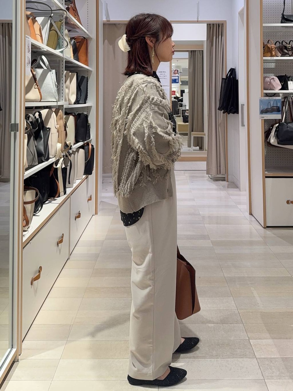 ブラック系のシャツ/ブラウス、ブラウン系のトートバッグ、ブラック系のパンプスを着用したレディースの春コーディネートの4枚目の写真