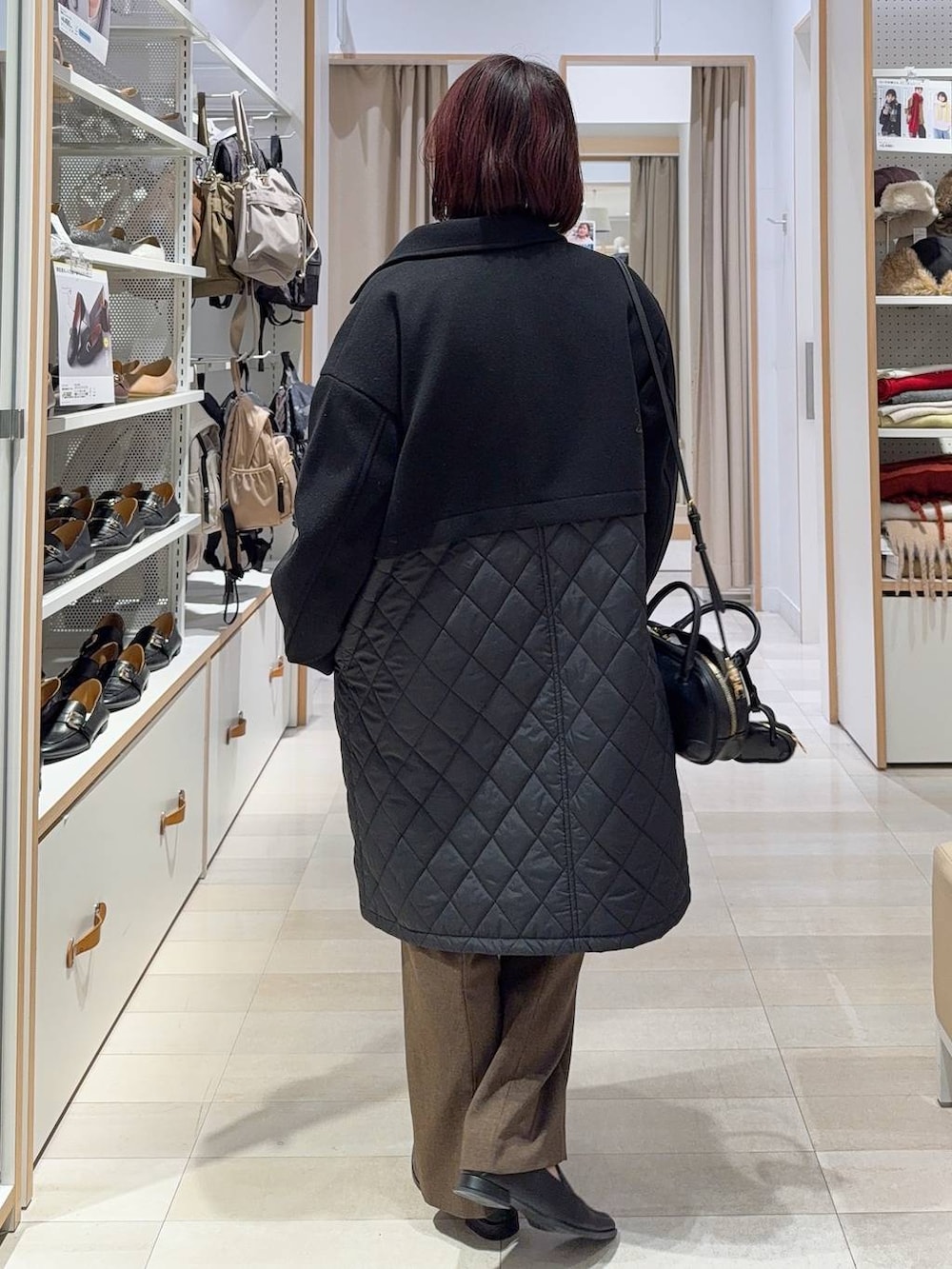 ブラック系のステンカラーコート、ブラウン系のその他パンツ、ブラック系のパンプスを着用したレディースの秋コーディネートの4枚目の写真