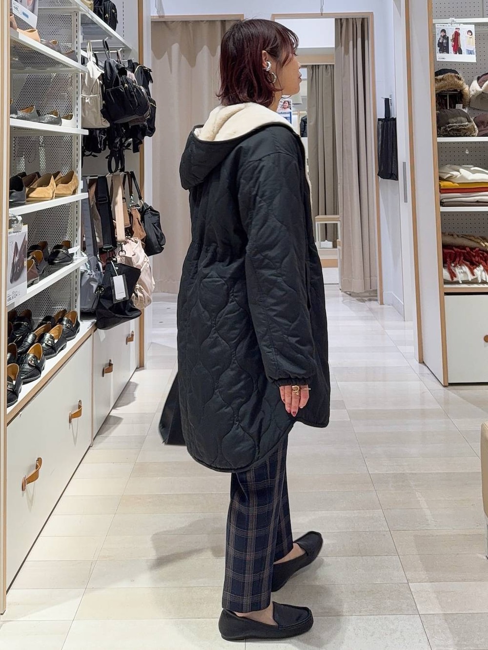 ブラック系のショルダーバッグ、ブラック系のブルゾン、ホワイト系のニット/セーターを着用したレディースの冬コーディネートの3枚目の写真