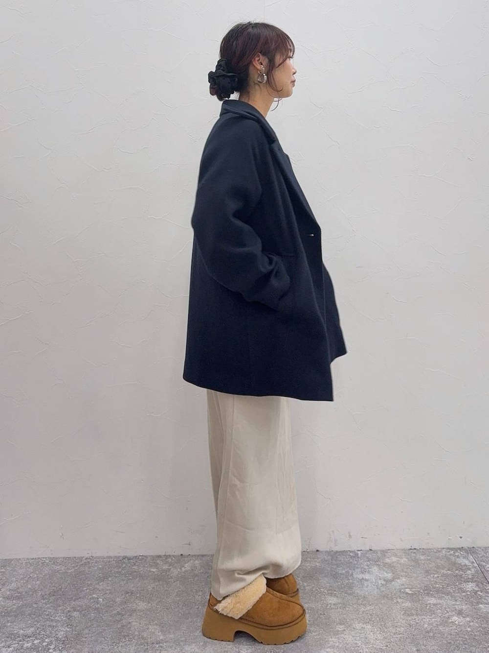 ホワイト系のスカート、ブルー系のチェスターコート、イエロー系のブーツを着用したレディースの冬コーディネートの3枚目の写真