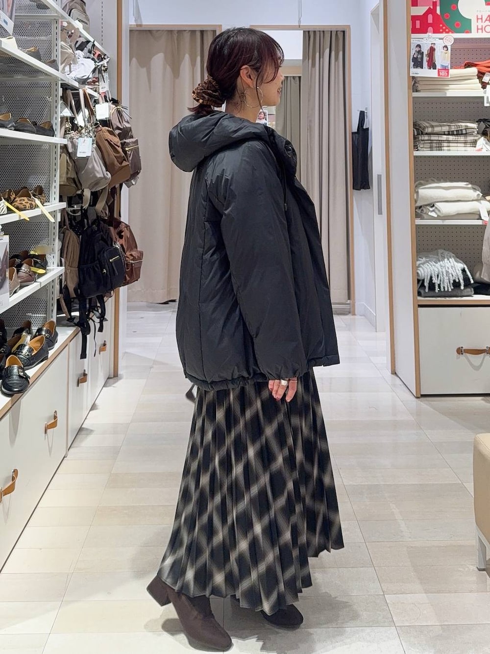 ブラウン系のショルダーバッグ、ブラック系のダウンジャケット/コート、ベージュ系のカーディガン/ボレロを着用したレディースの冬コーディネートの6枚目の写真