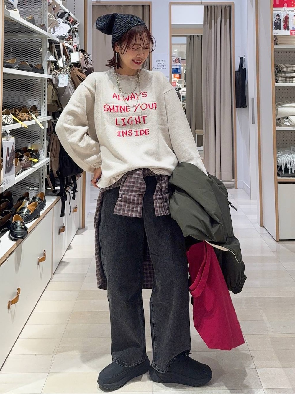 ブラック系のデニムパンツ、ブラウン系のシャツ/ブラウス、レッド系のトートバッグを着用したレディースの冬コーディネートの3枚目の写真